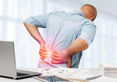 Back pain caused by improper sitting at a computer - physiotherapy can be a solution